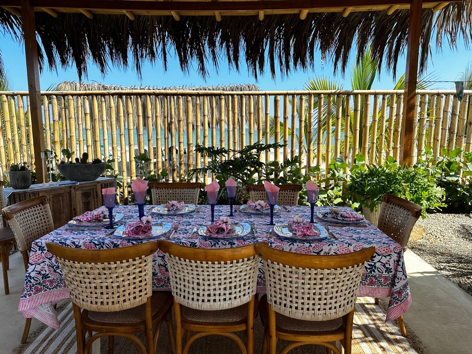 Mesa tropical bajo una terraza de palma frente al mar