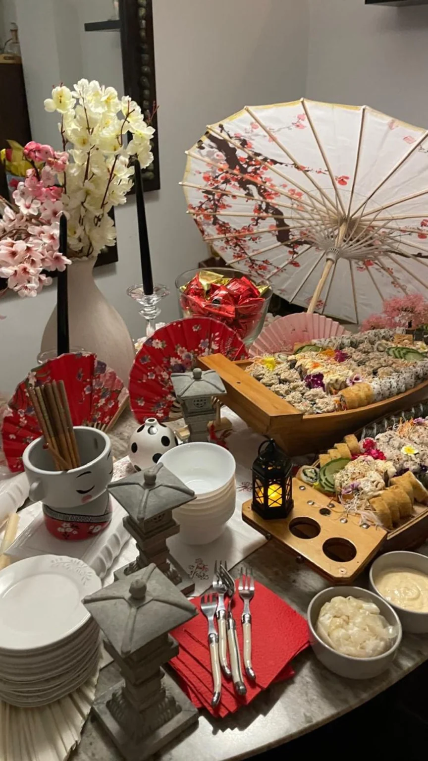 Mesa japonesa con sushi, orquídeas, sombrillas y faroles