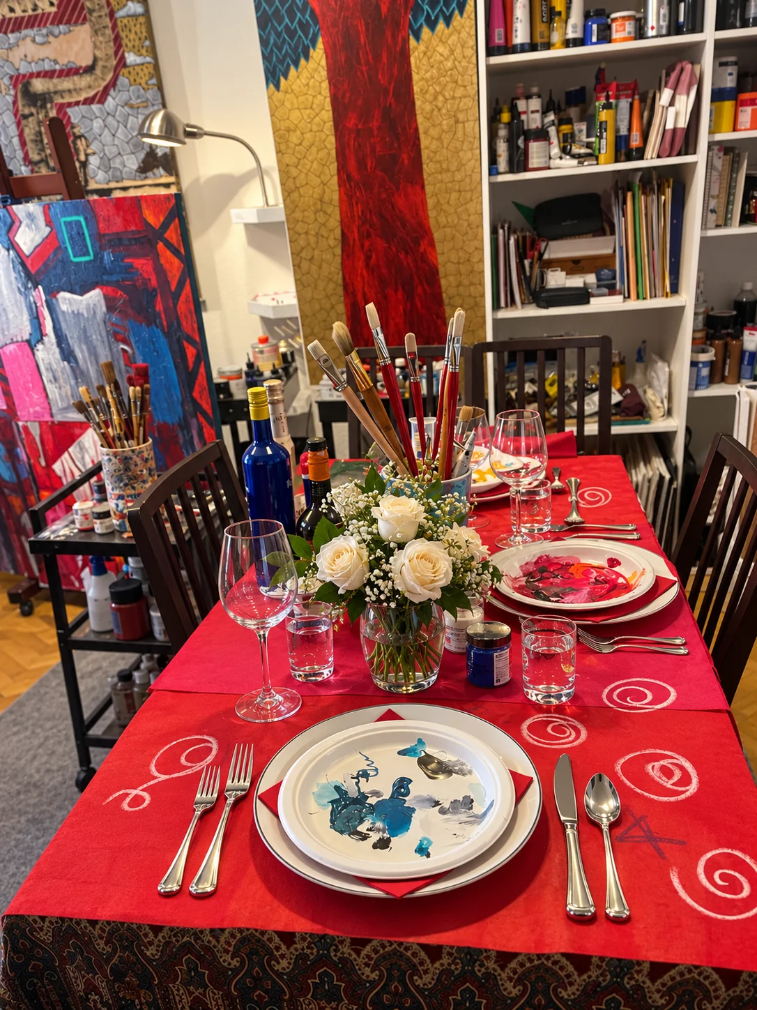 La mesa del artista con rosas blancas, pinceles y vajilla intervenida