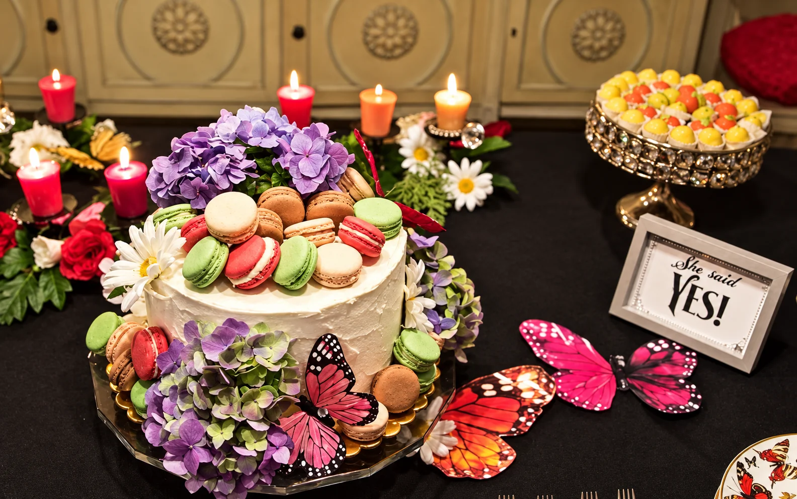 Mesa de dulces con torta, flores, macarons y mariposas